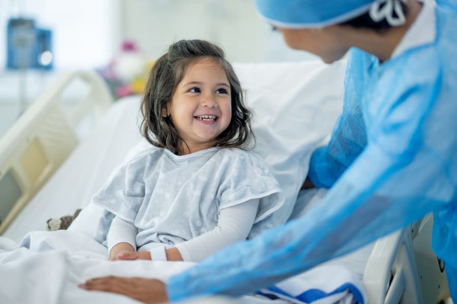 Surgeon checking on child patient after operation 