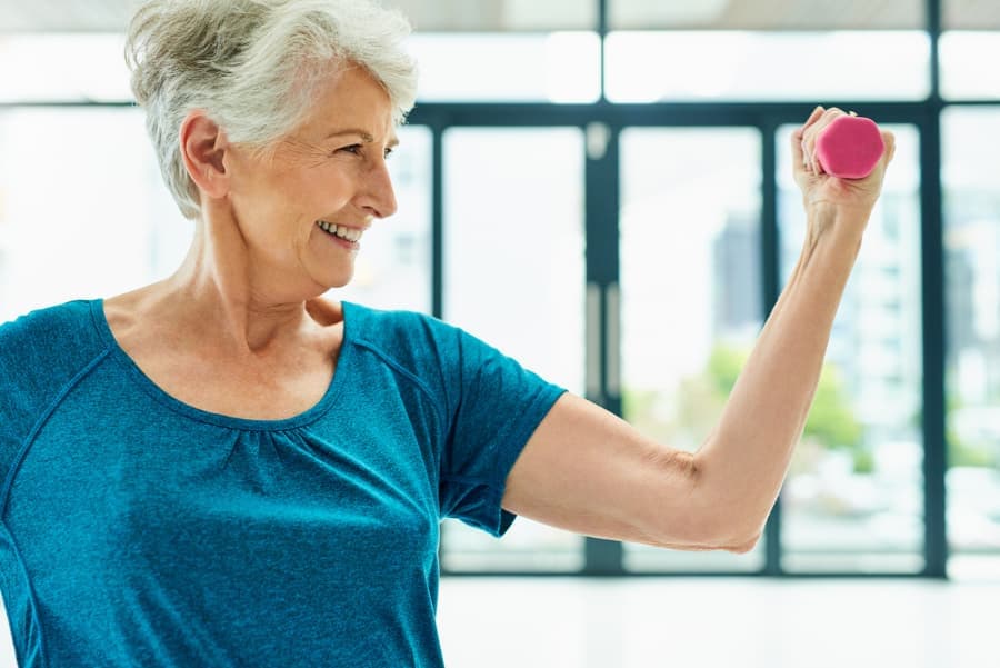 Senior woman doing strengthening exercise with small weight