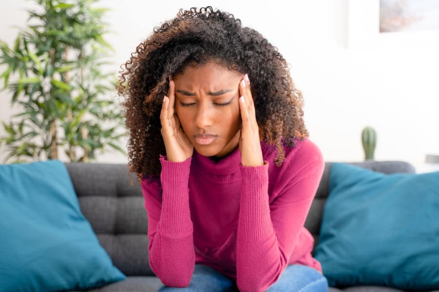 Woman suffering from headache massages temples