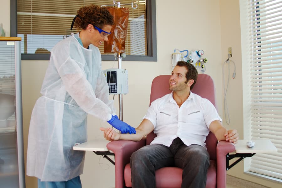 A nurse and a patient talk during an infusion treatment
