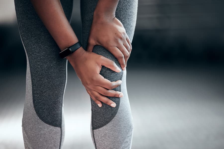 A patient holds a pained knee