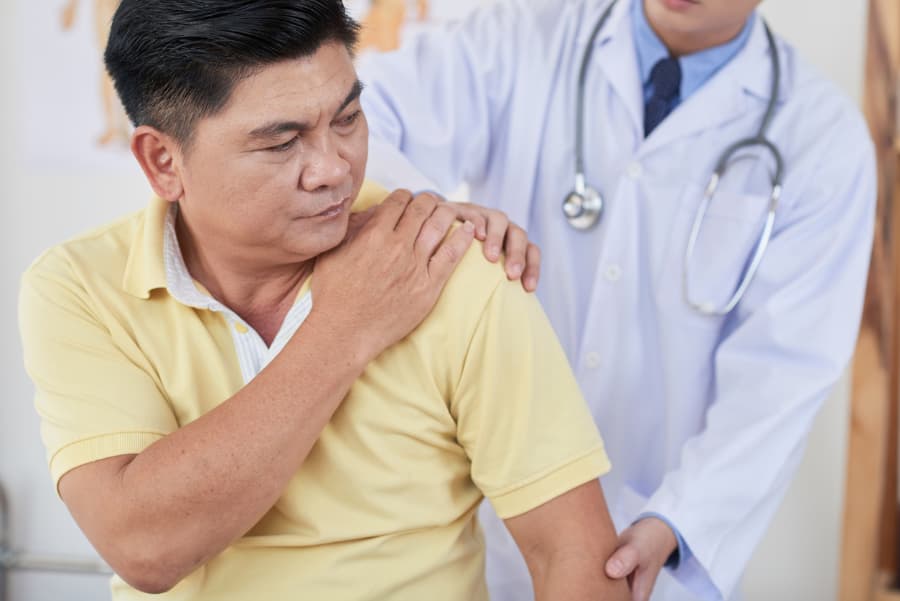 A man discusses shoulder pain with his physician