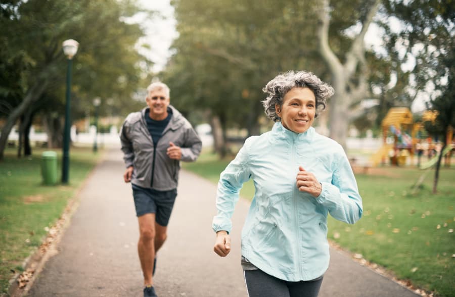 Two people jogging through a city park.