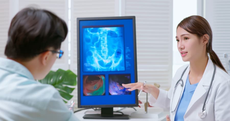 Doctor Explaining Colonoscopy Image To Patient