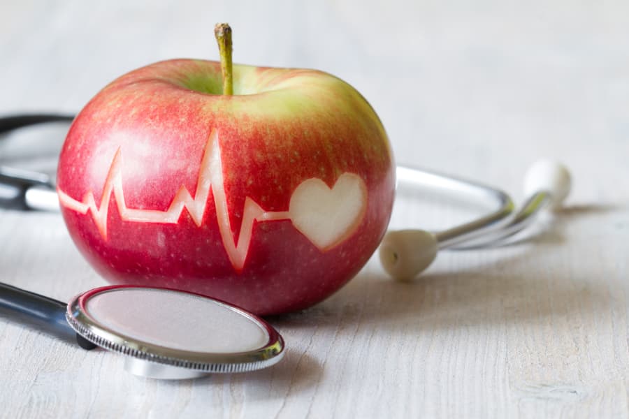 EKG results image and heart carved into an apple with stethoscope