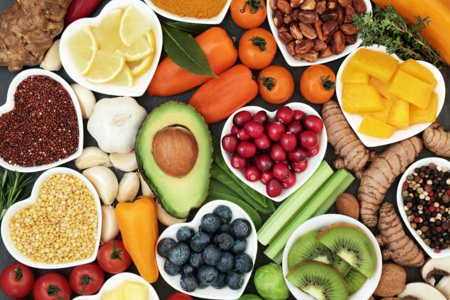 Various healthy superfoods on a table and placed in heart-shaped containers