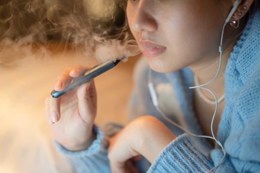 Young woman vaping with electronic cigarette