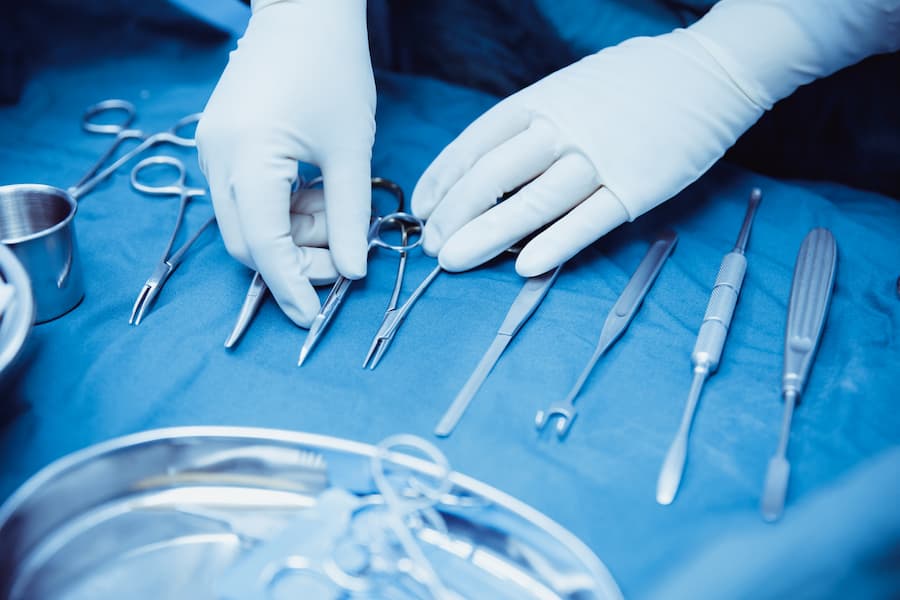 Surgical nurse arranging surgical tools in operating room 